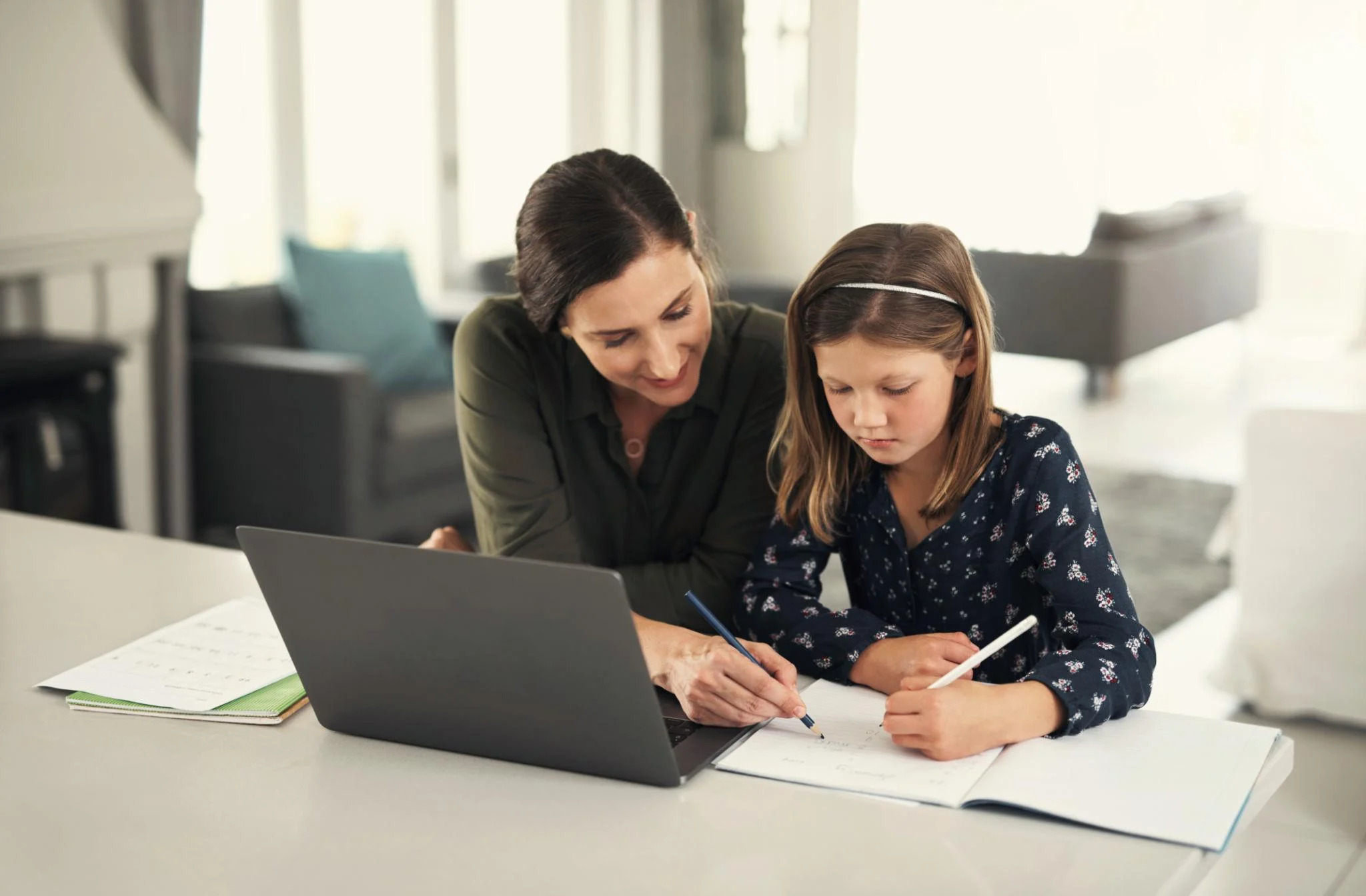 Parent supporting her child's homework at home while managing family responsibilities